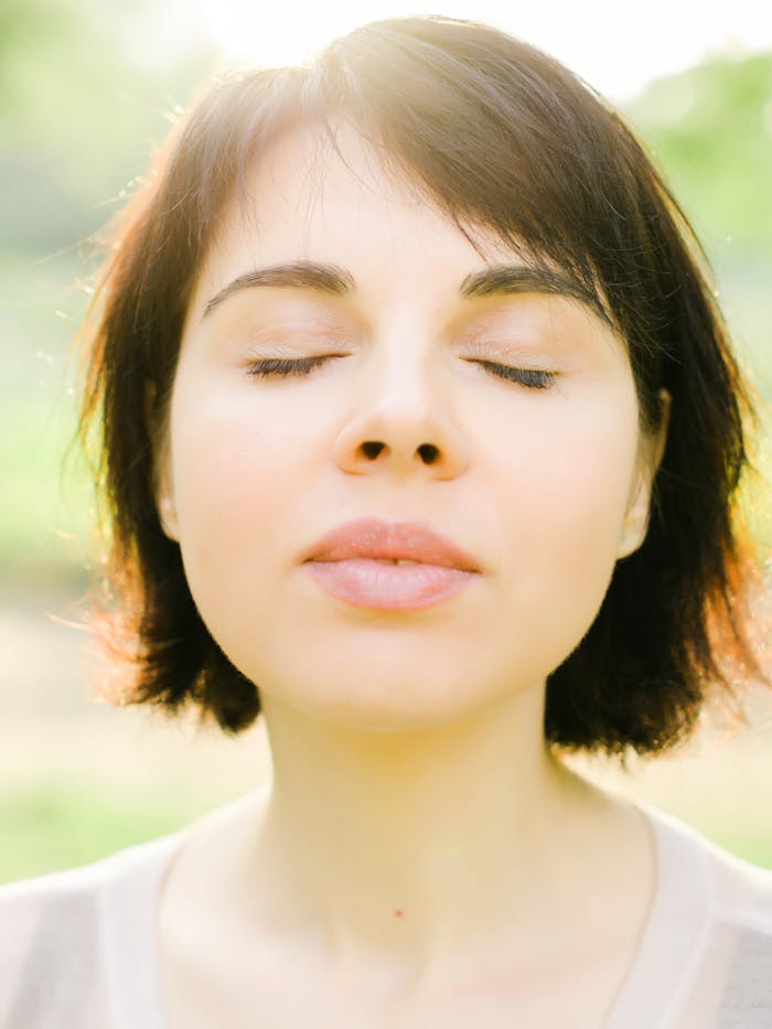 Serene outdoor portrait of a woman with closed eyes enjoying the summer sun in Ukraine.